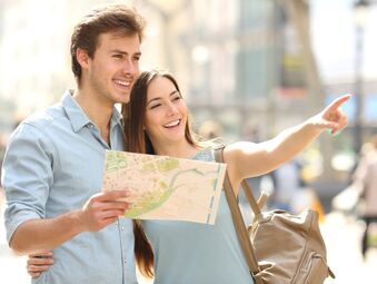 Couple in blue shirts using a paper map to navigate the city